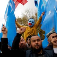 A masked Uighur boy takes part in a protest against China at a mosque in Istanbul in November 2018. The U.S. added 11 Chinese companies implicated in what it called human rights violations in connection with China\'s treatment of its Uighurs in Xinjiang, China, to the U.S. economic blacklist. | REUTERS 