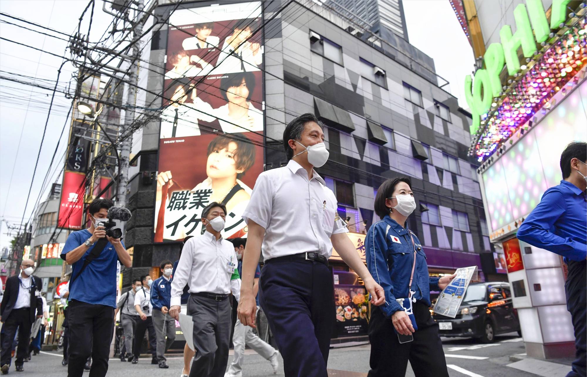 The head of Shinjuku ward, Yoshizumi Kenichi (center), asks for cooperation with measures against the pandemic in the Kabukicho district on Monday. | KYODO
