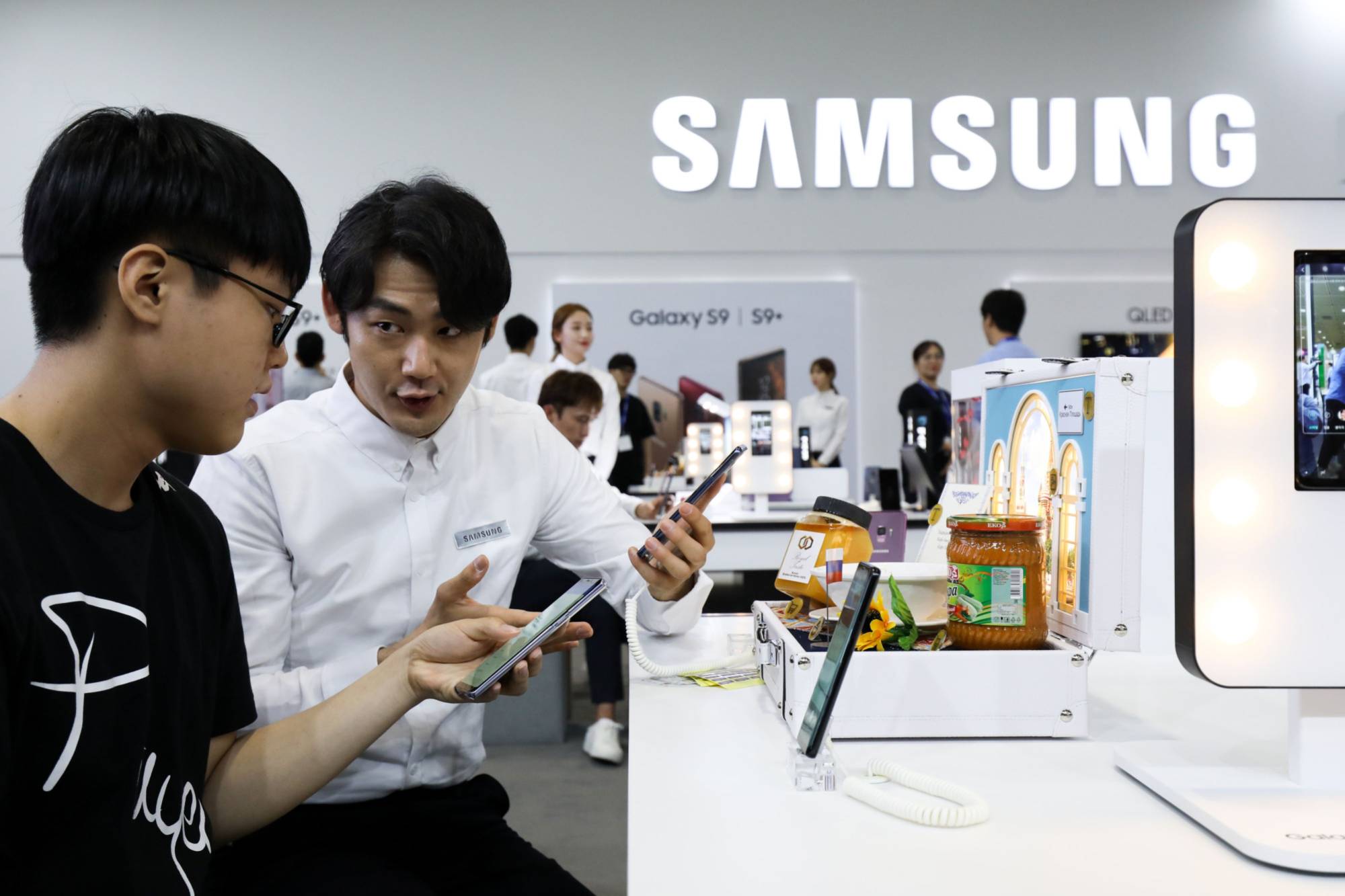 A salesman demonstrates a Samsung Electronics smartphone in Seoul. Companies in South Korea, with the aid of the government, are seeking out alternative methods to get around Japan's tightened export controls on special chemicals. | BLOOMBERG