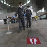 Workers spray disinfectant as a precaution against a new coronavirus at the National Museum of Korea in Seoul on Wednesday.  | AP