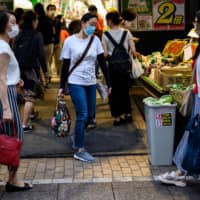 Customers shop at a supermarket in Tokyo on July 1. Many people in Japan are refraining from dining out amid the coronavirus pandemic. | AFP-JIJI