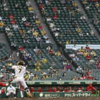 Fans watch a game between the Tigers and Carp on Wednesday at Koshien Stadium in Nishinomiya, Hyogo Prefecture. | KYODO