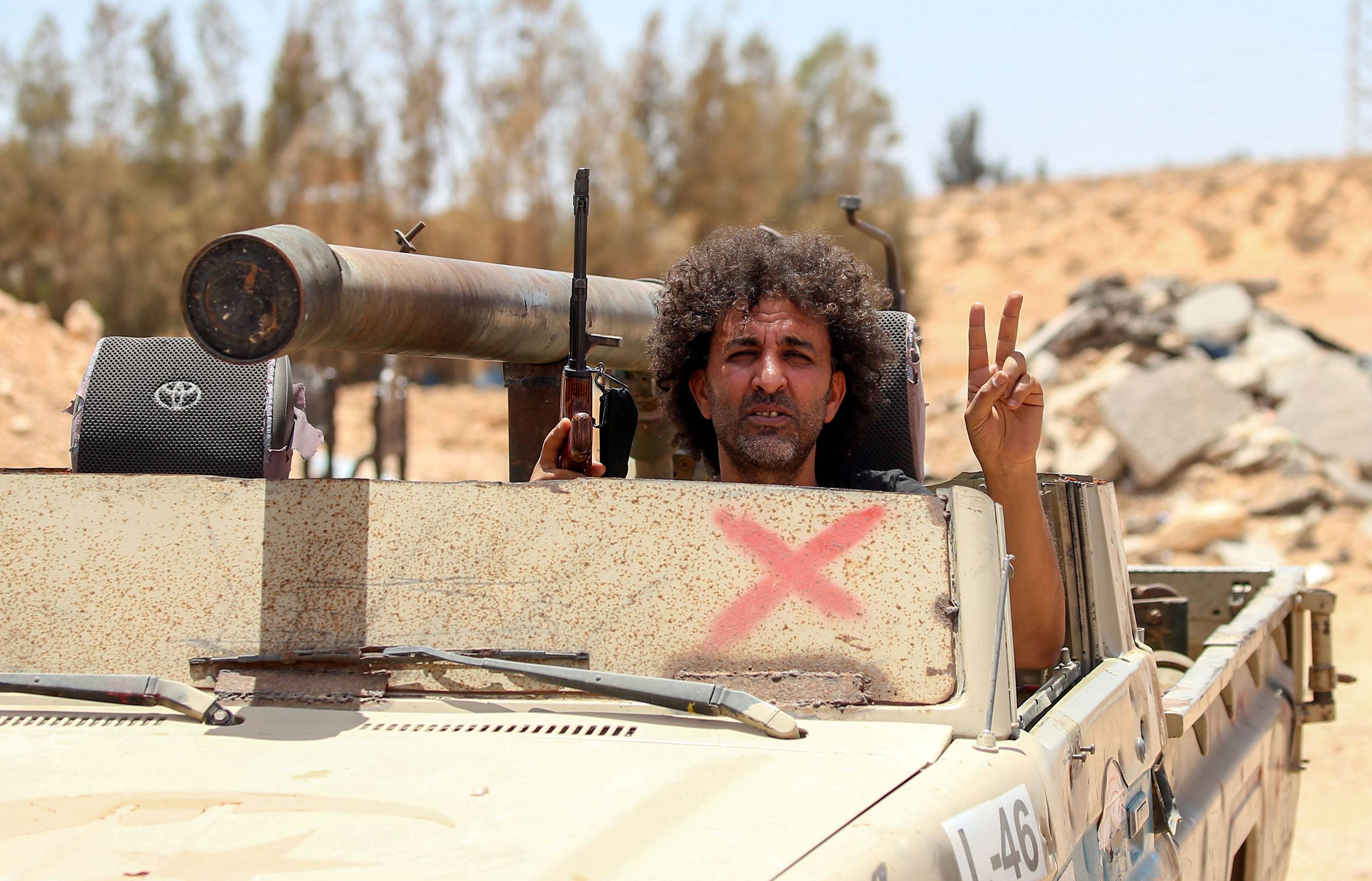 Fighters loyal to the UN-recognized Libyan Government of National Accord (GNA) secure the area of Abu Qurain, halfway between the capital Tripoli and Libya's second city Benghazi, against forces loyal to Khalifa Haftar, who is based in eastern Benghazi, on July 20, 2020. | AFP-JIJI