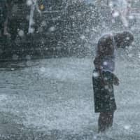 A man cools off in splash pad at Washington Square Park in New York City on Saturday.  | BLOOMBERG 