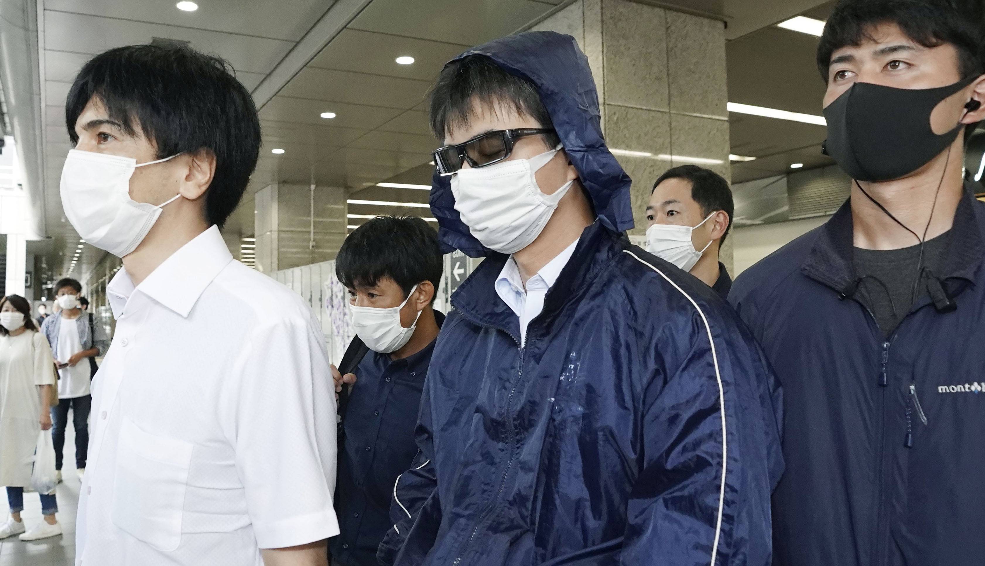 Naoki Yamamoto (center), a doctor in Tokyo who was arrested on suspicion of helping a woman die, arrives at Kyoto Station on Thursday. | KYODO