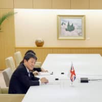 Foreign Minister Toshimitsu Motegi holds a teleconference with Liz Truss, the British trade secretary, in Tokyo on June 9. | KYODO
