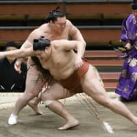 Abi (front) competes against yokozuna Hakuho during the Osaka Basho on March 15 in Osaka. | KYODO

