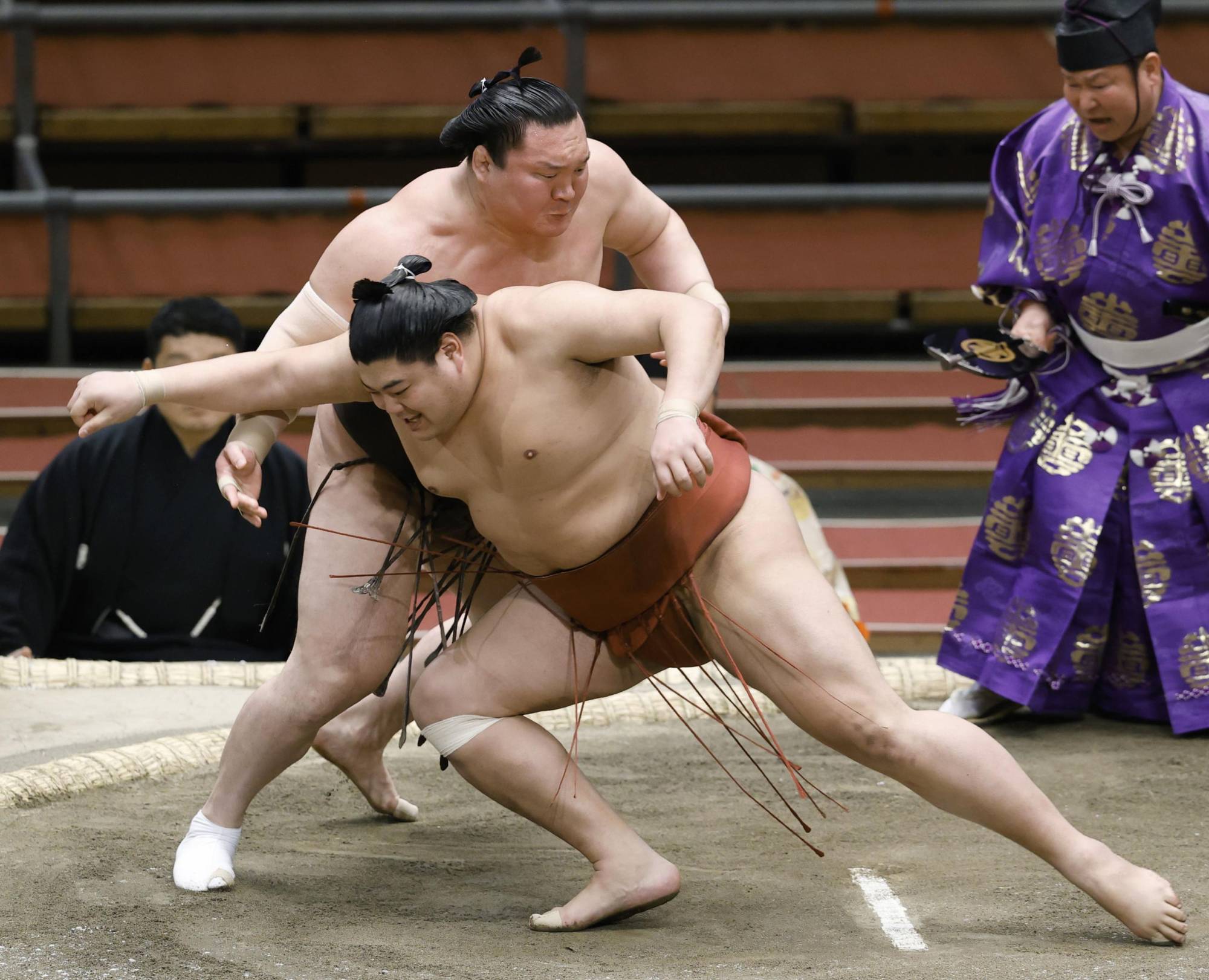 Abi (front) competes against yokozuna Hakuho during the Osaka Basho on March 15 in Osaka. | KYODO