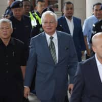 Malaysia\'s former prime minister Najib Razak (center) arrives for a court appearance at the Duta court complex in Kuala Lumpur in August 2018. Najib, fighting dozens of charges over a multi-billion-dollar graft scandal, faces his first verdict on Tuesday.  |  AFP-JIJI