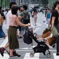 Pedestrians cross a street in Tokyo\'s Ginza shopping district on Saturday. | AFP-JIJI