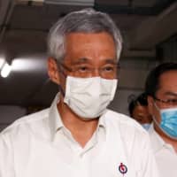 Singapore\'s Prime Minister Lee Hsien Loong arrives at a People\'s Action Party branch office, as ballots are counted during the city\'s general election on July 11. | REUTERS