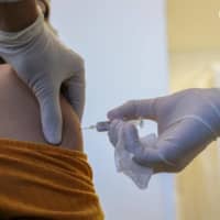 Handout picture released by the Sao Paulo State Government press office shows a volunteer receiving the COVID-19 vaccine during the trial stage of the vaccine produced by the Chinese company Sinovac Biotech at the Hospital das Clinicas in Sao Paulo state, Brazil, on July 21. | SAO PAULO STATE GOVERNMENT / VIA AFP-JIJI