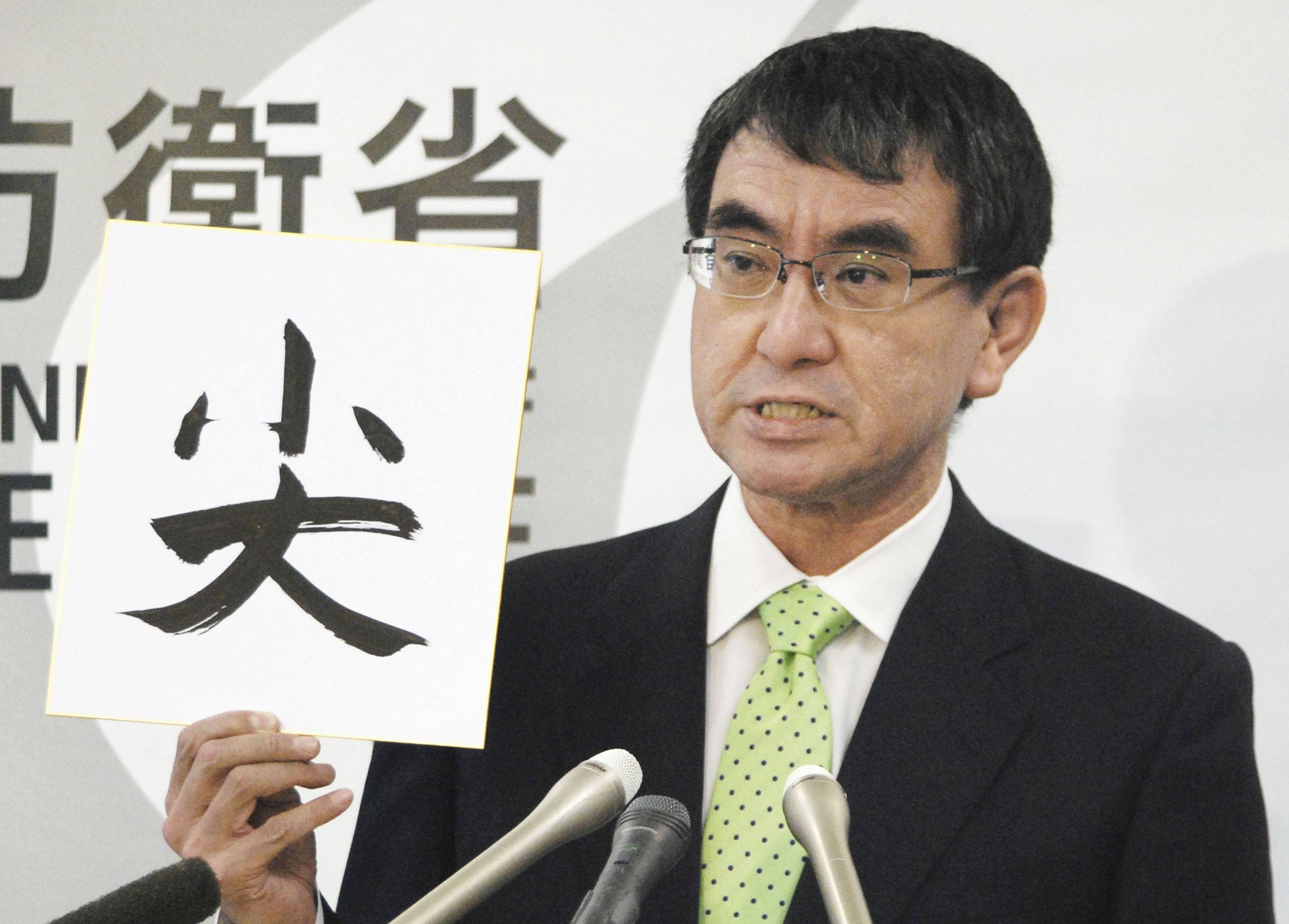 Defense Minister Taro Kono holds up a sign with the first kanji character for the word Senkaku at the Defense Ministry last December. | KYODO