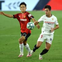 Mallorca\'s Takefusa Kubo (left) vies for the ball with Sevilla midfielder Olivier Torres during a July 12 game in Seville. | AFP-JIJI