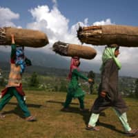 Bakarwal nomadic women carry firewood in Kashmir. A new law makes it possible for people from outside Kashmir to become permanent residents, sparking fears among locals that nonlocals will get priority when it comes to housing, jobs and education. | AFP-JIJI