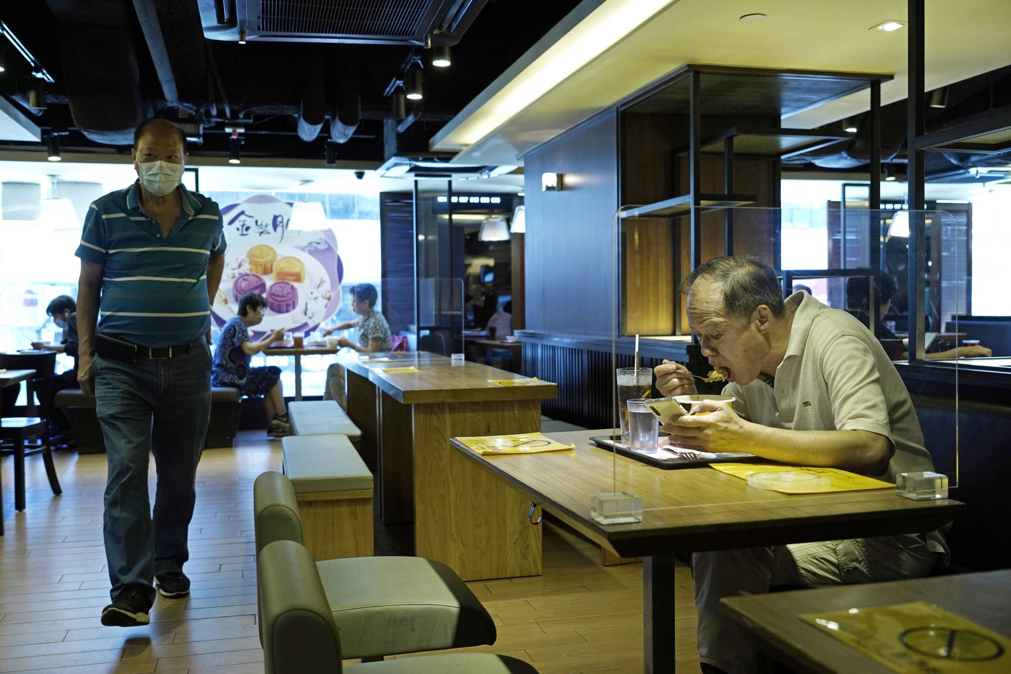 Measures to prevent the spread of COVID-19 have gotten incrementally tighter in Hong Kong in recent weeks. Dining-in was originally banned for dinner, but that rule was later expanded to also include lunch. | AP