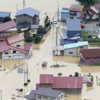 Houses are seen flooded in Okura, Yamagata Prefecture, Wednesday morning after the Mogami River began to overflow late Tuesday. | KYODO