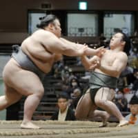 Takakeisho (left) pushes Enho during their bout at the July Grand Sumo Tournament at Ryogoku Kokugikan. Takakeisho pulled out of the meet on Thursday. | KYODO