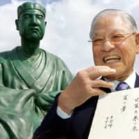Former Taiwanese President Lee Teng-hui holds his own haiku poem in front of a statue of Matsuo Basho at the Basho Museum in Tokyo in 2007.  | AP 