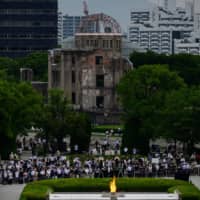 People gather in front of the ruins of the Hiroshima Prefectural Industrial Promotion Hall, now commonly known as the atomic bomb dome, during the 75th anniversary memorial service for atomic bomb victims at the Peace Memorial Park in Hiroshima on Aug. 6. | AFP-JIJI