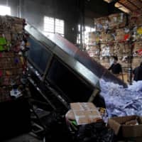 Laborers work at a paper products recycling station in Shanghai. | REUTERS