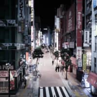 Pedestrians walk along a nearly empty street in Shinjuku.  | BLOOMBERG