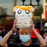 A demonstrator holds a stuffed Hamtaro toy  during a protest demanding the resignation of Thai Prime Minister Prayuth Chan-o-cha in Bangkok last month. | REUTERS