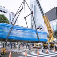 An old train car that has served as a tourist information center outside Tokyo\'s Shibuya Station is lifted up with a crane early Monday morning. | SHIBUYA WARD / ODATE CITY / VIA KYODO