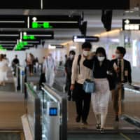 Passengers head to their respective departure gates at the domestic terminal of Tokyo\'s Haneda Airport on July 25. | AFP-JIJI