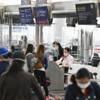 People wait before check-in counters at Chubu Centrair International Airport in Tokoname, Aichi Prefecture, on June 17 as the airport resumed some international flights. | KYODO