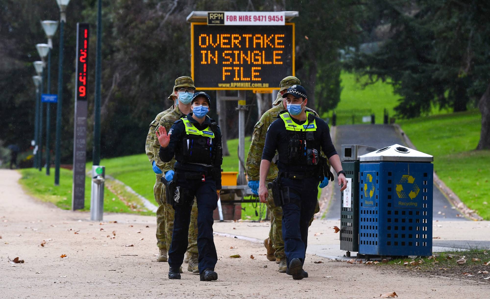Police officers and soldiers patrol a popular running track in Melbourne on Tuesday after the state announced new restrictions as the city battles fresh outbreaks of the COVID-19 coronavirus.  | AFP-JIJI