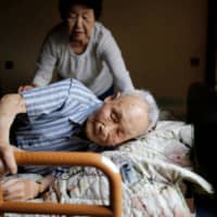 Kang Bok-soon helps her husband, Lee Hak-rae, the last surviving Korean war criminal from World War II. | REUTERS