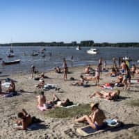People cool off in the waters of the Danube river in Belgrade on Saturday as Serbia endures a heat wave.  | AFP-JIJI