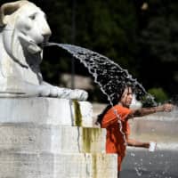A tourist cools off at the Barcaccia fountain by the Spanish Steps in central Rome on Saturday amid a heat wave.  | AFP-JIJI