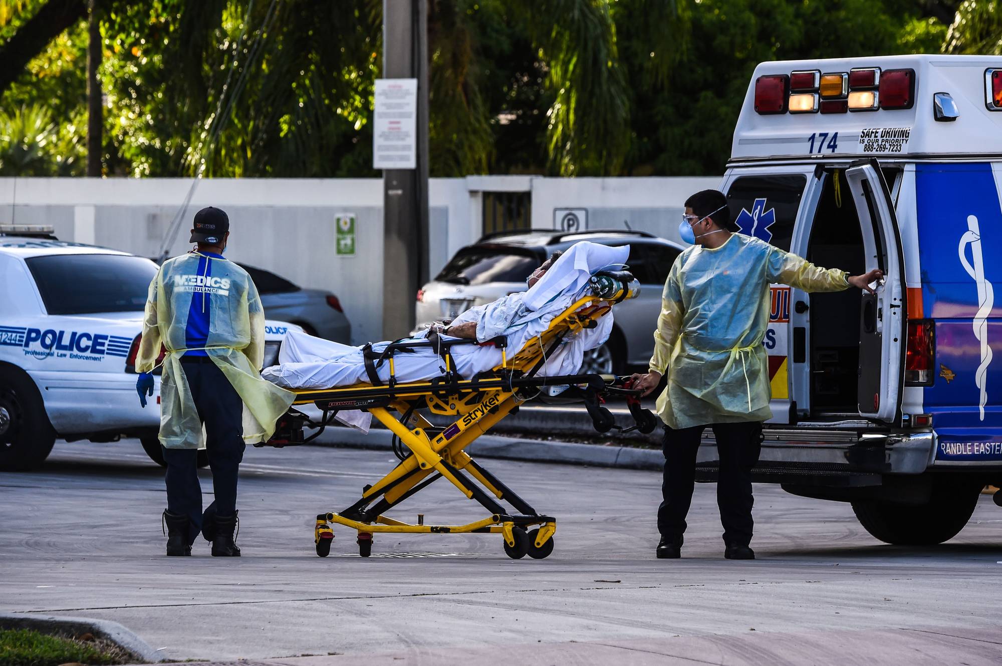 Medics transfer a patient on a stretcher from an ambulance outside of a hospital near Miami. | AFP-JIJI