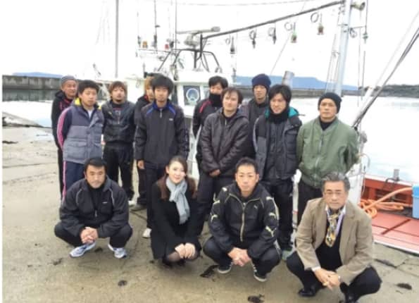 Chika Tsubouchi (front, second from left), CEO of Ghibli and operator of the Hagi Oshima Sendanmaru fishing fleets in Yamaguchi Prefecture, poses with fleet workers. | GHIBLI