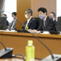 Yasutoshi Nishimura (right), minister in charge of the coronavirus response, speaks at a meeting of the government\'s advisory panel on coronavirus countermeasures in Tokyo on Friday. | KYODO