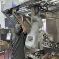 Robots that can flip burgers, make salads and even bake bread are in growing demand as virus-wary kitchens try to put some distance between workers and customers. |  ROBOTICS / VIA AP