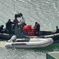 A dinghy and life-jackets, believed to have been taken from migrants picked up from boats in the Channel by U.K. Border Force officers, arrive in the port of Dover on the south-east coast of England on Sunday.  | AFP-JIJI