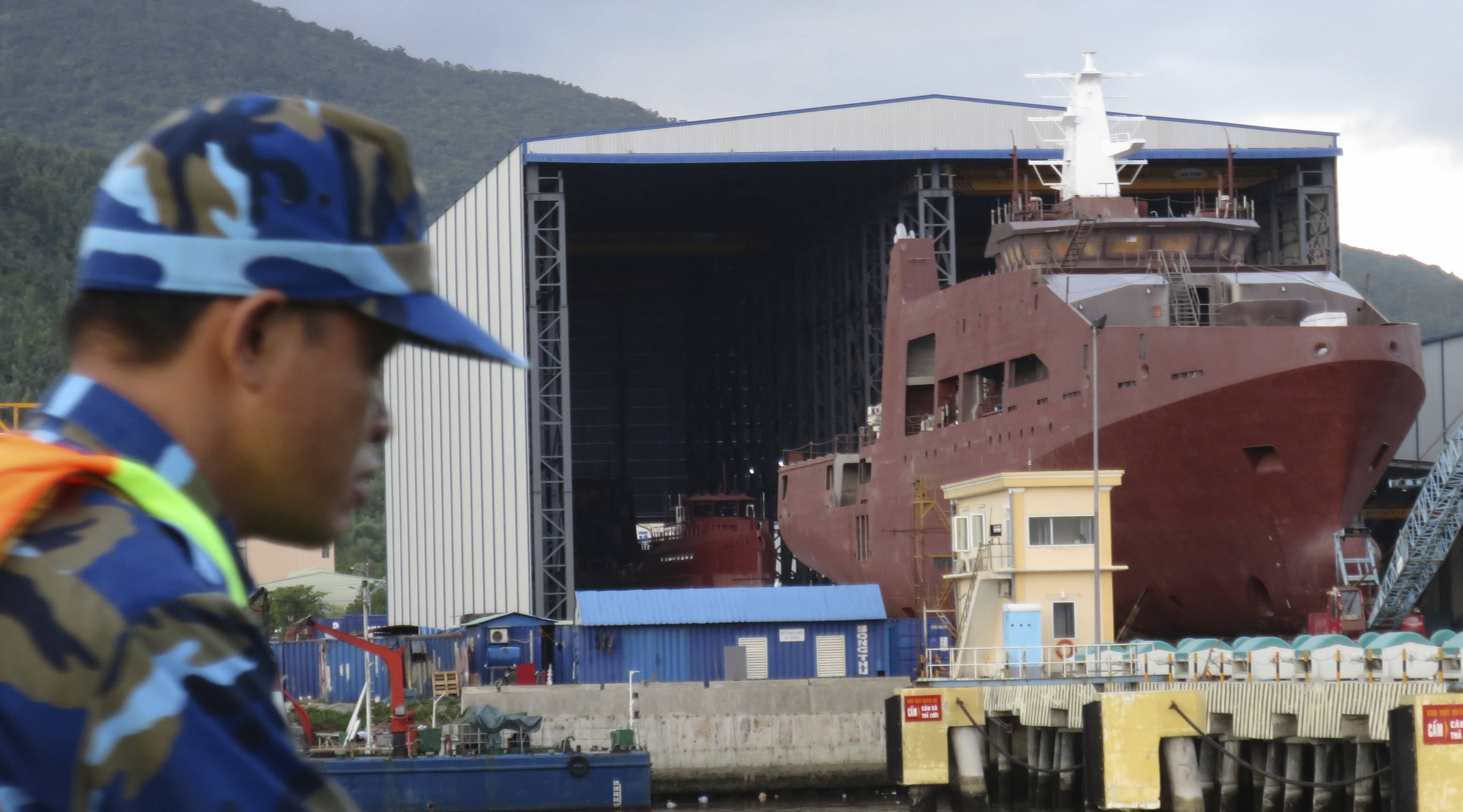 A Vietnam Coast Guard crewman looks out near a patrol ship being built at a shipyard in Danang in July 2014. Japan has signed a ¥36.6 billion deal with Vietnam to provide the Southeast Asian country with six patrol boats to boost its maritime law enforcement capabilities. | REUTERS