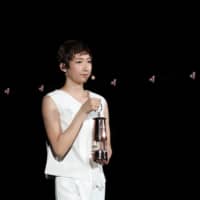 Rikako Ikee holds a lantern containing the Olympic flame during an event marking the one-year countdown to the postponed 2020 Tokyo Olympics on July 23 at Tokyo\'s National Stadium. | POOL / VIA REUTERS