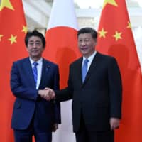 Chinese President Xi Jinping, shown meeting Prime Minister Shinzo Abe in December, calls united front work a “magic weapon” for advancing Chinese Communist Party goals. | REUTERS
