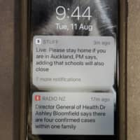 A news alert is displayed on a mobile phone in Christchurch, New Zealand, Tuesday. New Zealand Prime Minister Jacinda Ardern said Tuesday that authorities have found four cases of the coronavirus in one Auckland household from an unknown source, the first cases of local transmission in the country in 102 days.  | AP