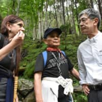 Susanne Bayly-Yukawa and Shuji Oda, who lost family members in the 1985 JAL 123 crash, confront Yuji Akasaka, the airline\'s president, on Mount Osutaka in Gunma Prefecture on Aug. 12, 2019. | COURTESY OF SUSANNE BAYLY-YUKAWA
