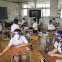 Hot in here: Students wear face shields and masks during a class to prevent the spread of coronavirus. However, critics say the students are at risk of heatstroke due to the measures.  | KYODO
