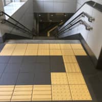 Tactile paving can guide a visually impaired person to the top of a flight of stairs at a train station in Tokyo. | KATHRYN WORTLEY
