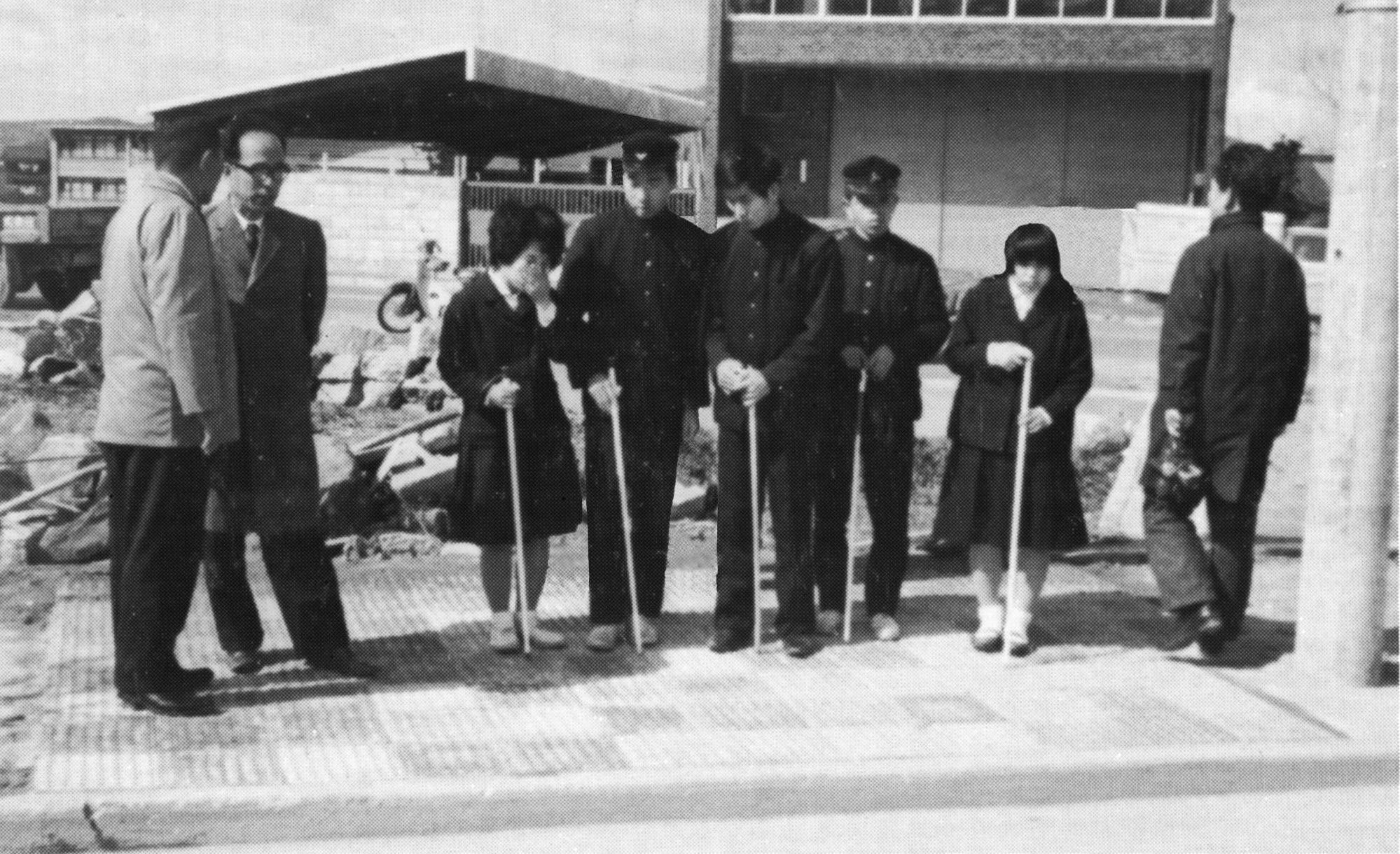 Teachers and students test tactile paving at a road crossing in Okayama Prefecture in 1967. | COURTESY OF TRAFFIC SAFETY RESEARCH CENTER, INC.