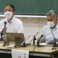 Tenri University vice president Tatsuki Okada (left) speaks in a news conference in Tenri, Nara Prefecture, on Monday. | KYODO