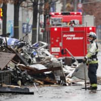 Firefighters inspect collapsed buildings in Sapporo on Dec. 17, 2018, following an explosion the night before. | KYODO