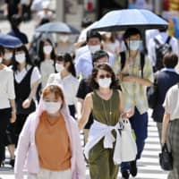 People walk the Shinjuku area of Tokyo on Thursday. | KYODO